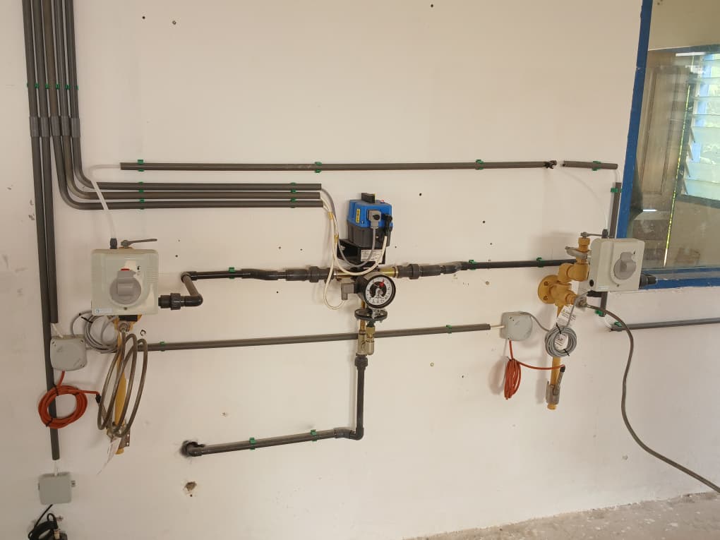 Wall-mounted water line with dosing control unit, gauge, valves, and service piping